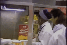a woman standing in front of a popcorn machine