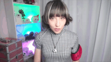 a woman wearing a plaid shirt and a necklace with a pendant that says " i love you "