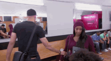 a man is standing next to a woman in a waiting room with a sign that says ' barber shop ' on it