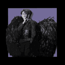 a black and white photo of a person with black wings