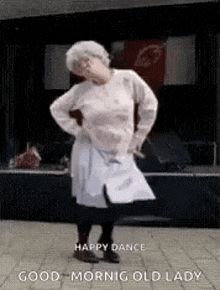 an elderly woman is dancing on a stage with a cat .