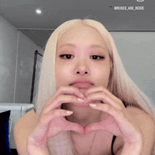 a woman making a heart shape with her hands with the name rosie on the bottom