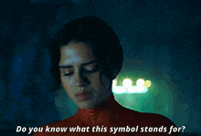 a woman in a red sweater is asking do you know what this symbol stands for