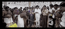 a group of people praying in a temple with a man holding a tray
