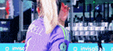 a woman wearing a purple jersey with the name merridell on the back of it