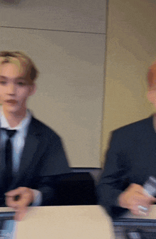 a man in a suit and tie is sitting at a table