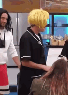 a man in a yellow wig is standing next to a woman in a red skirt .