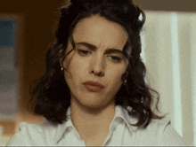 a close up of a woman 's face with a slight smirk on her face