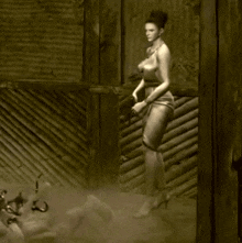 a naked woman is standing in front of a wooden fence