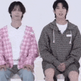 a couple of men are sitting next to each other on a chair .