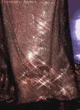 a close up of a shiny mesh fabric with a purple background