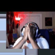 a person wearing headphones is covering their face