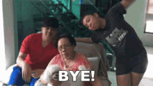 a group of people are posing for a picture and one of them is holding a dog and says bye .