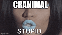 a close up of a woman 's face with blue lipstick and the words cranimal stupid written on it .