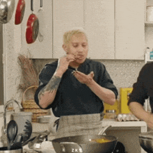 a man in an apron is eating something in a kitchen with the letters zk on it