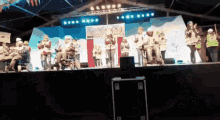 a group of people are standing on a stage with a sign that says 2012