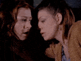 two women are looking at each other with one wearing earrings