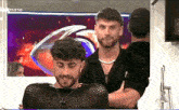 two men are standing next to each other in front of a screen that says ' mano ' on it