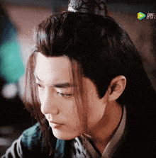a man with long hair and a crown on his head looks down at something