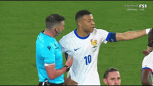 a soccer player with the number 10 on his shirt talks to a referee