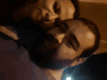 a man with a beard kisses another man on the cheek