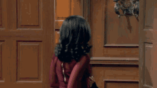 a woman in a red dress is standing in an open doorway