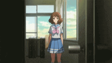 a girl in a school uniform is standing in a doorway looking out a window