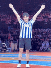 a man wearing a blue and white striped shirt that says ' sbs ' on the front