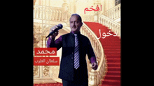 a man in a suit and tie is singing into a microphone in front of stairs
