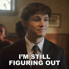 a man in a suit and tie with the words i 'm still figuring out below him