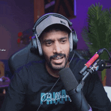 a man wearing headphones is singing into a microphone with the word bulkan on his shirt
