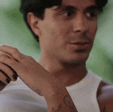 a man with a tattoo on his wrist that says ' s '