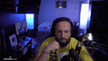 a man wearing headphones and a yellow shirt with the letter u on the front