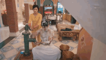 a woman is washing a man with soap and water in a bathroom