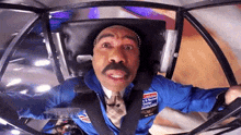 a man with a mustache wearing a cowboy hat is sitting in a vehicle