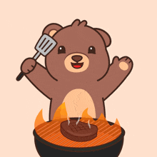 a brown teddy bear is holding a spatula over a grill with a steak on it
