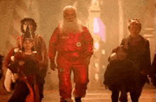a group of people dressed as santa claus and witches are walking down a dark street .