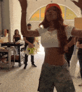 a woman in a white crop top and camo pants dancing
