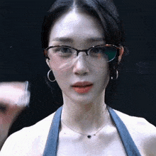 a close up of a woman wearing glasses and a heart necklace