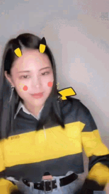 a woman wearing a yellow and black striped shirt with a pikachu on her face