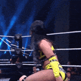 a woman in a wrestling ring with a w on the ring post