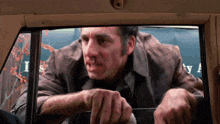 a man in a brown jacket is looking out the window of a car with the word liberty on the back