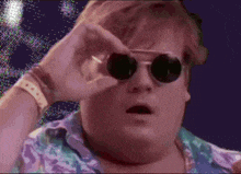 a fat man wearing sunglasses and a purple shirt looks surprised