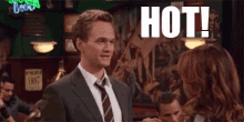 a man in a suit and tie is standing next to a woman in a bar and says `` hot '' .