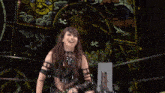a woman in a black outfit is smiling and making a funny face