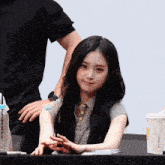 a woman sitting at a table with a cup that says mcdonalds