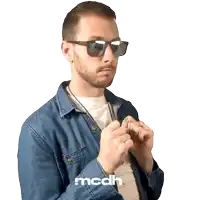 a man wearing sunglasses and a denim shirt has the letters mcdh on his shirt