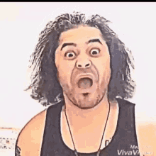 a man with long hair and a beard is making a funny face with his mouth wide open .
