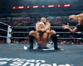 a wrestling match is taking place in front of a crowd and a banner that says raw