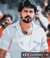 a man with a beard is wearing a white shirt and a necklace
